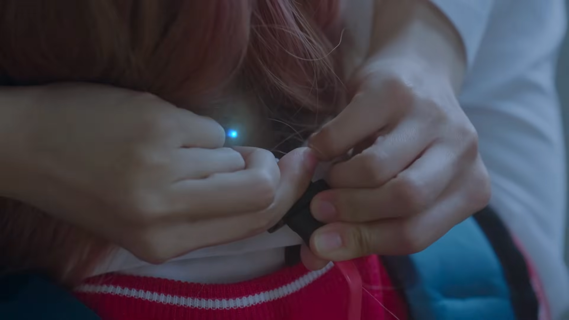 Vivi plugging in a wire to her neck.